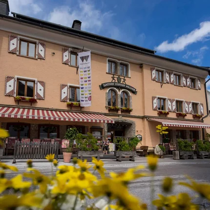 Ski- und Wanderhotel Steffner-Wallner © Hotel Steffner-Wallner Gasthof Steffner Wallner mit gelben Blumen im Vordergrund bei blauem Himmel