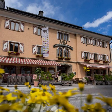 Ski- und Wanderhotel Steffner-Wallner © Hotel Steffner-Wallner Gasthof Steffner Wallner mit gelben Blumen im Vordergrund bei blauem Himmel