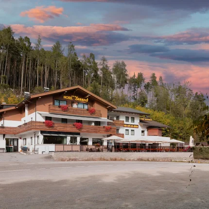 B&B Hotel Sonneck © Alfred Tschager Hotel mit Terrasse vor Wald und buntem Abendhimmel