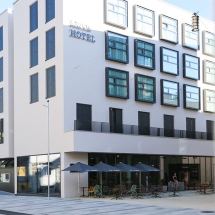 arte Hotel Kufstein © arte Hotel Kufstein Modernes Hotelgebäude mit Außenterrasse und Sonnenschirmen