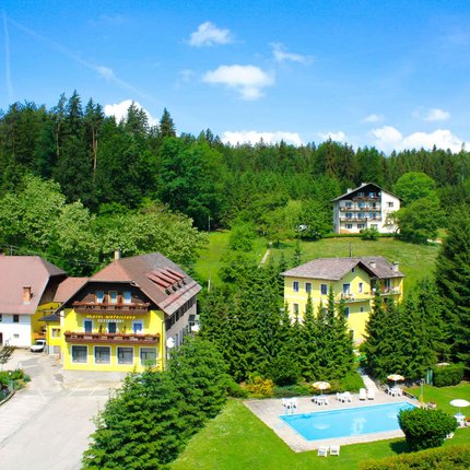 Hotel Jerolitsch © Creativo Media GmbH - Emiliano Soravia Ländliche Häuser mit Pool umgeben von grünen Bäumen und Wäldern unter blauem Himmel