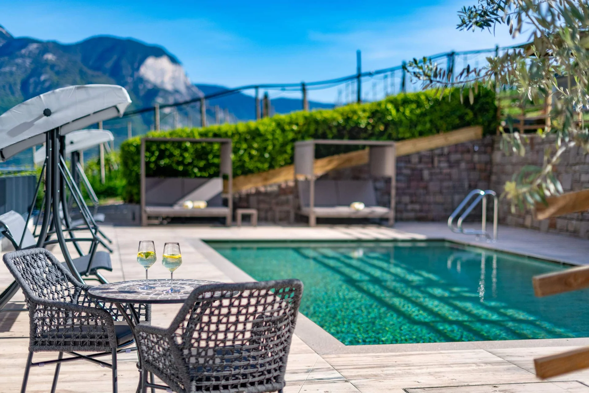 Velontour © Compusol.it - Mitterer Zublasing Dietmar Pool mit Sitzbereich und zwei Gläsern auf dem Tisch bei sonnigem Wetter