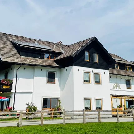 Landhaus Lungau © Landhaus Lungau Großes weißes Haus mit braunem Dach und Berglandschaft im Hintergrund