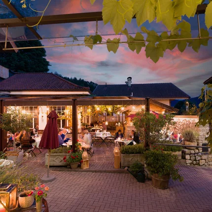 Hotel Gasthaus Blaue Quelle © Blaue Quelle in Erl - Dabernig Abendessen auf der beleuchteten Terrasse eines Restaurants mit Gästen