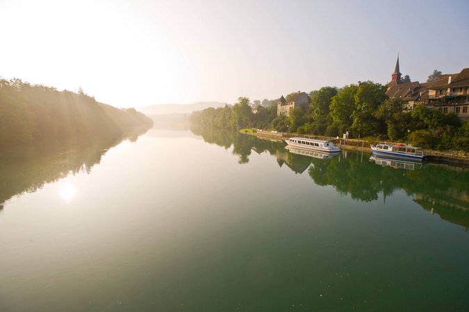 Velontour © Bad Zurzach Tourismus AG Fluss mit Booten und Stadt im Morgenlicht