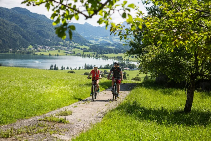 Velontour © Velontour Zwei Fahrradfahrer auf einem Weg mit Blick auf See und Berge