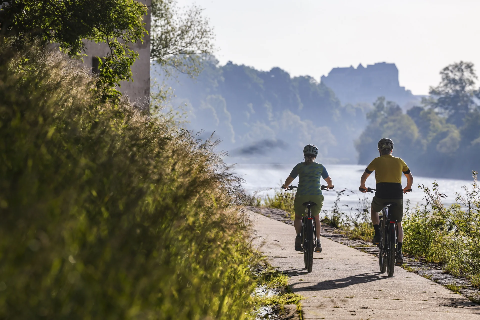 Velontour © Velontour - Heiko Mandl Zwei Radfahrer auf einem Flussweg bei sonnigem Wetter