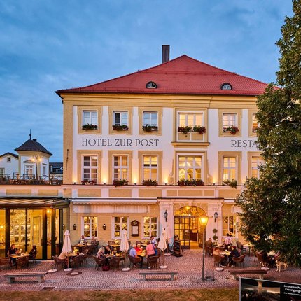 Hotel Zur Post © Hotel Zur Post Abendansicht des Hotels Zur Post mit beleuchtetem Außenbereich und Gästen