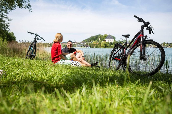 Velontour © Velontour Zwei Radfahrer entspannen am Seeufer mit ihren Fahrrädern im Gras