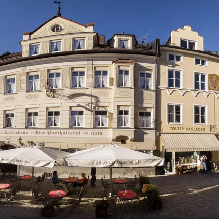 Kolberbräu © Ralf Gerard Historisches Gebäude mit Außenbereich eines Cafés in sonniger Stadtstraße
