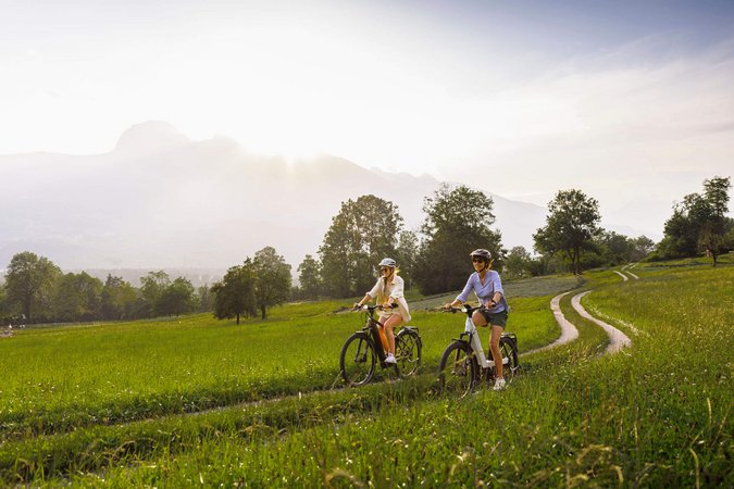 Velontour © Christoph Schöch Zwei Frauen fahren mit dem Fahrrad auf einem Feldweg bei sonnigem Wetter
