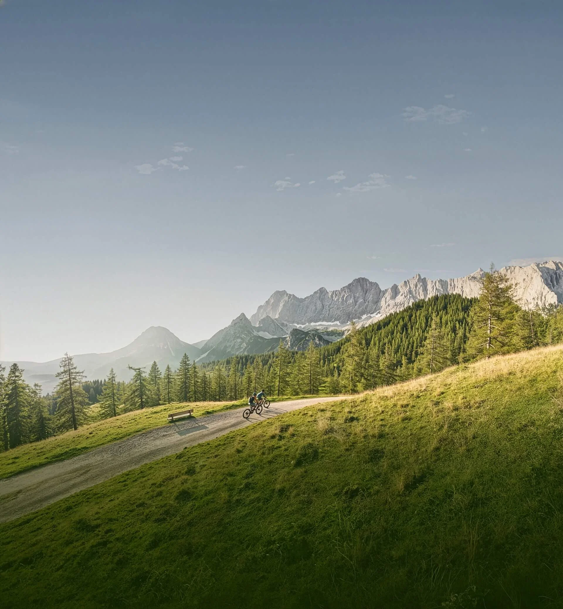 Velontour Zwei Mountainbiker auf einem Weg in den Bergen bei klarem Himmel