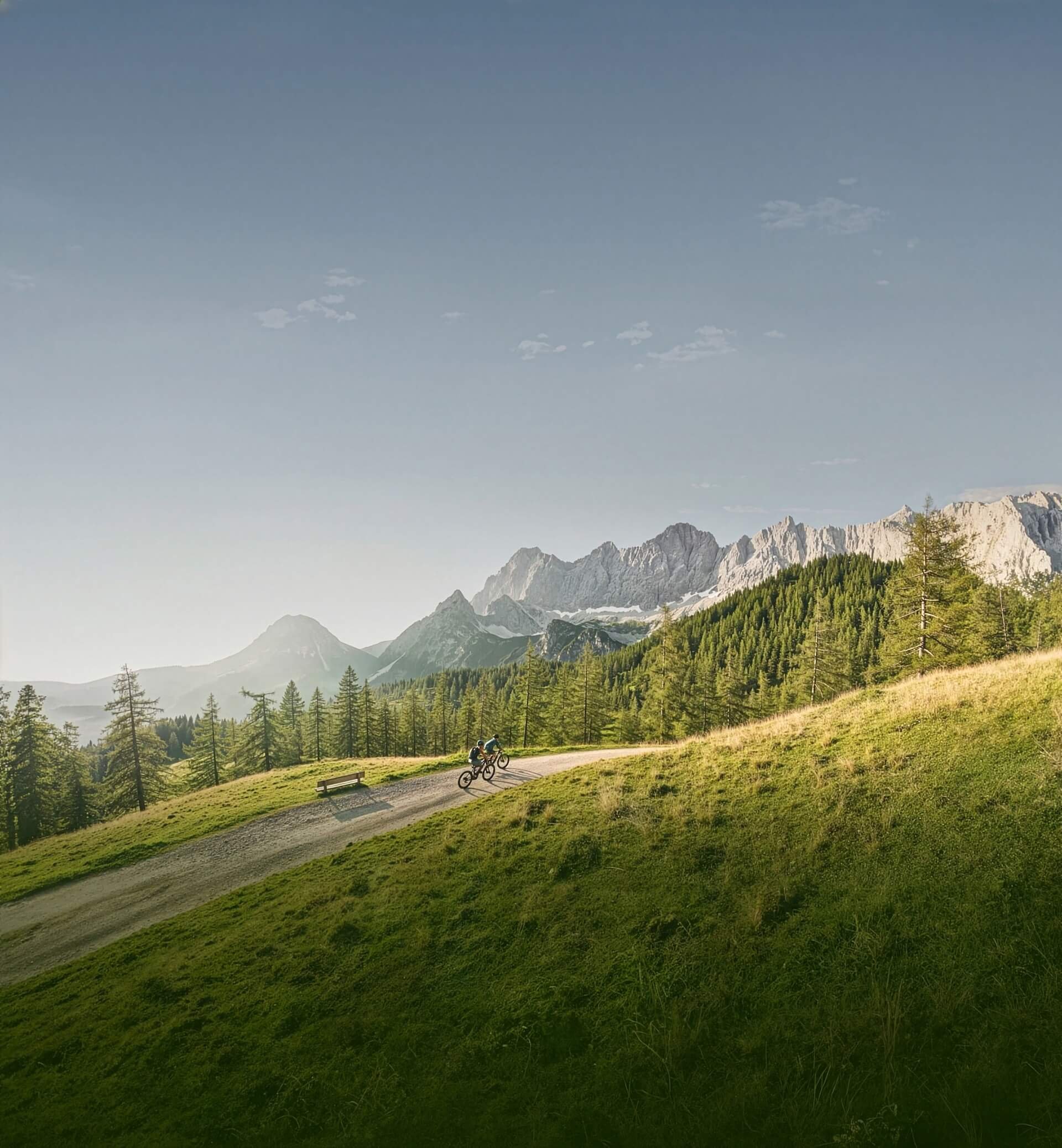 Velontour Zwei Mountainbiker auf einem Weg in den Bergen bei klarem Himmel